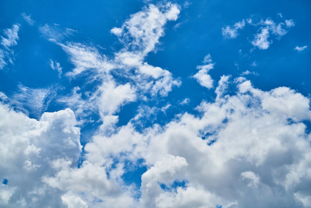 Vibrant cumulus clouds scattered across a clear blue sky, highlighting a perfect day.